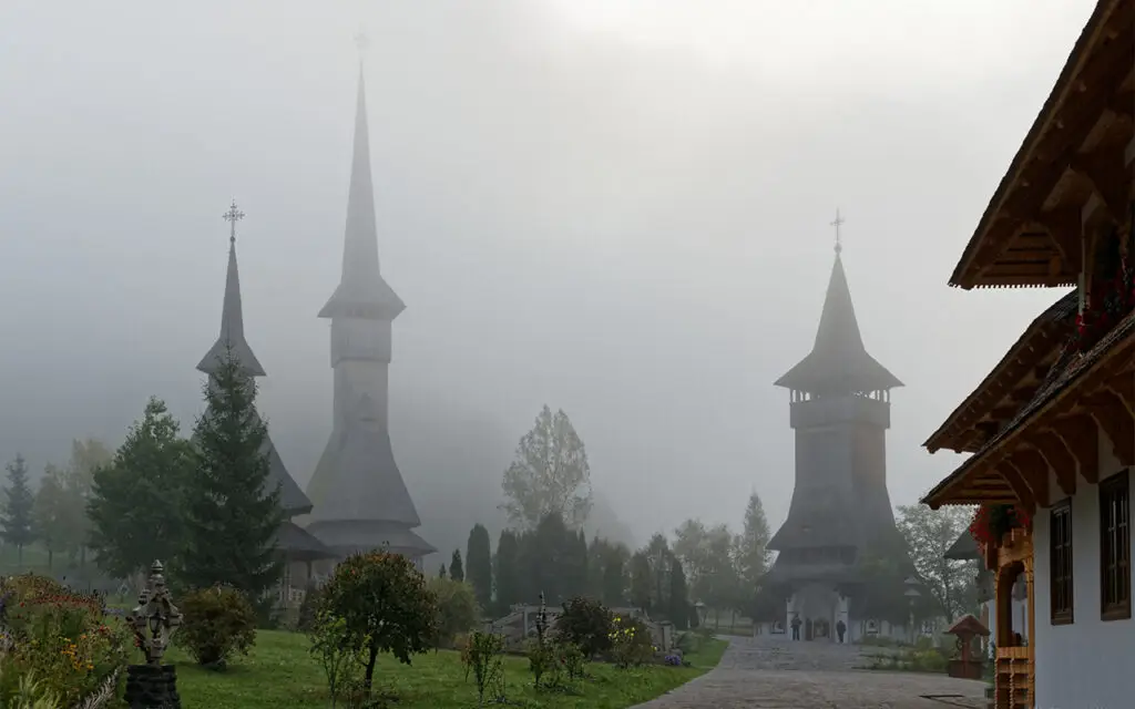 Monastère Bârsana — Au cœur d'une Transylvanie de légendes, le monastère de Bârsana, église de bois de 56 mètres classée à l'UNESCO, dressée sur une colline artificielle de sépultures.
